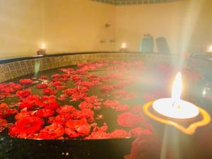 a large pool of red flowers with a candle in it at Kottai Veedu Pondicherry in Pondicherry
