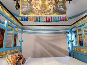 a bedroom with a painting on the ceiling at Kottai Veedu Pondicherry in Pondicherry