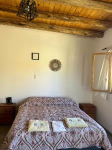 a bedroom with a bed with towels on it at Complejo ROSA OLIVA Cabañas y Habitaciones Rurales in Albardón