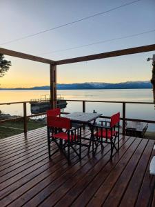 una mesa y sillas en una terraza con vistas al lago en Los Dones Departamentos DAT, en San Carlos de Bariloche