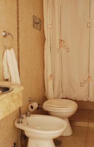 a bathroom with a toilet and a sink at Hotel Frossard in Buenos Aires