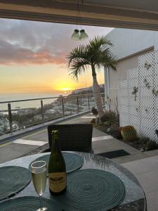 una mesa con una botella de vino y una copa en Apartman VERA - Beautiful Sunshine And Sea View, en Puerto Rico de Gran Canaria 19 fotos más
