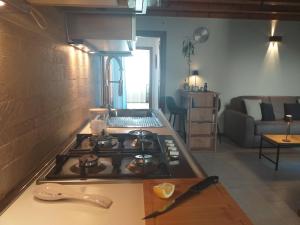 a kitchen with a stove top and a living room at Casin dei Nobili Dépendance in Venice