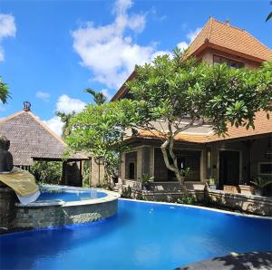 a swimming pool in front of a house at Villa Djojonagoro in Ketewel
