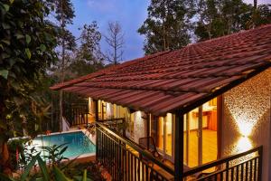 a house with a deck and a swimming pool at Tealawn Pool Villa, Munnar in Munnar