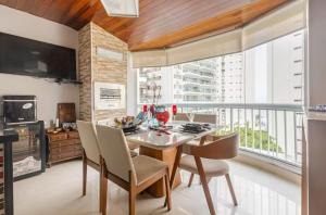 a kitchen with a dining room table and chairs at Flat ao lado do Mar Four Season in Guarujá
