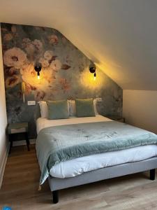 a bedroom with a bed with a floral wall at Hotel Eden in Saint Malo
