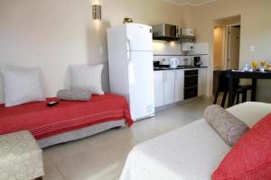 a living room with a couch and a white refrigerator at Departamentos Recalada Suites in Monte Hermoso