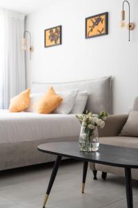 een woonkamer met een bank en een tafel met een vaas met bloemen bij סי סייד אילת חדר משפחתי מפנק עם נוף לים in Eilat +2 foto's