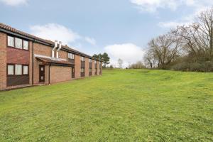 an empty field next to a brick building at Days Inn Hotel Sedgemoor in Rooks Bridge