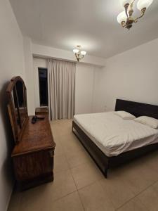 a bedroom with a bed and a dresser and a mirror at النزهة2 in Cairo