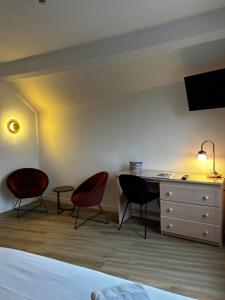 1 dormitorio con 2 sillas, escritorio y 1 cama en Hotel Eden, en Saint-Malo