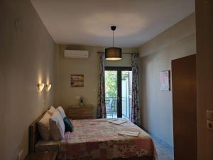 a bedroom with a bed and a sliding glass door at House Anna Sarti in Sarti