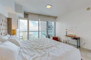 ein Schlafzimmer mit einem weißen Bett und einem großen Fenster in der Unterkunft Iconic Views in Miami