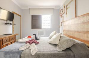 a bedroom with a large bed with pillows on it at Flat ao lado do Mar Four Season in Guarujá +21 photos