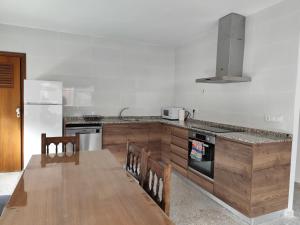 a kitchen with a wooden table and a counter top at La Casa de los Alemanes in Gaibiel