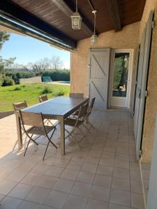 a wooden table and chairs on a patio at Villa avec piscine dans le Luberon in La Tour-dʼAigues
