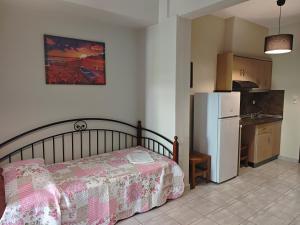 a bedroom with a bed and a kitchen with a refrigerator at House Anna Sarti in Sarti