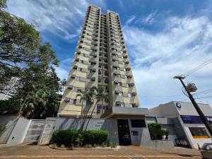 Un edificio alto con una palmera delante. en Apt Centro 3 quartos 2 banheiros com garagem, en Foz do Iguaçu