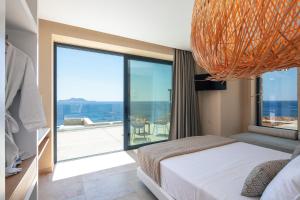 A bed or beds in a room at Seafront elegant villas, with infinity pools & devine views!
