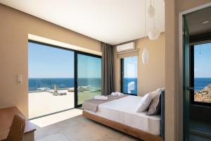 A bed or beds in a room at Seafront elegant villas, with infinity pools & devine views!