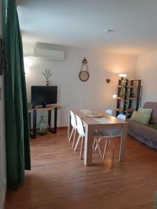 a living room with a table and chairs and a couch at les sables d'or grau du roi in Le Grau-du-Roi