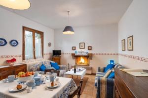 ein Wohnzimmer mit Tisch und Stühlen und einem Kamin in der Unterkunft Podere Oliveta in Poggibonsi