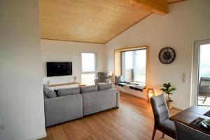 un soggiorno con un divano e un tavolo di Ferienwohnung Traumpanorama im HerberHaus Hunsrück a Hattgenstein