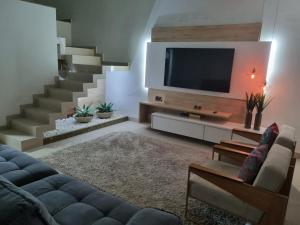 アラルアマにあるCasa Araruama, Região dos Lagosのソファとテレビのあるリビングルーム