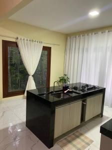 une cuisine avec un comptoir noir et une fenêtre dans l'établissement Casa Aconchego da Serra - Pacoti, à Pacoti