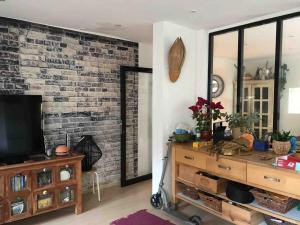 a living room with a tv and a brick wall at Maison de ville avec jardin in Nice