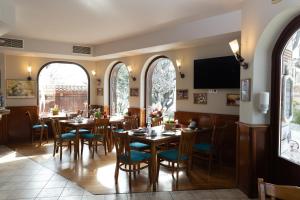 a restaurant with tables and chairs and a television at Family Hotel St Stefan Nessebar in Nesebar