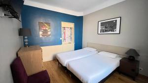 two beds in a room with blue walls at Villa Liberté in Villejuif