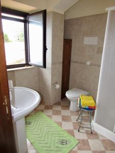 a bathroom with a sink and a toilet and a window at Villa Tramonto Capo d'Orlando in Naso