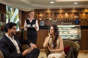 a group of people in a restaurant with a waiter at Golden Sands Suites in Dubai