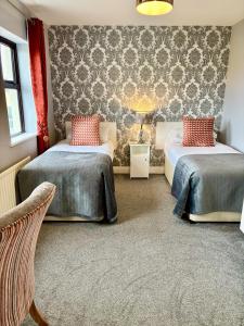 una camera d'albergo con due letti e una sedia di Killaran House a Killarney