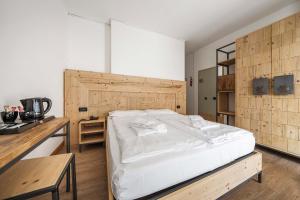 a bedroom with a large bed and a wooden wall at Hotel Olimpia in Cortina dʼAmpezzo