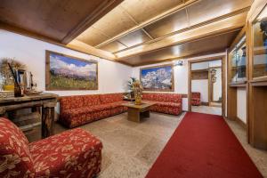 a living room with red couches and a red rug at Hotel Olimpia in Cortina dʼAmpezzo