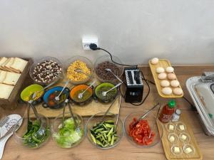 ein Tisch mit Schüsseln voller Gemüse und anderen Zutaten in der Unterkunft Kerben Hotel in Naryn
