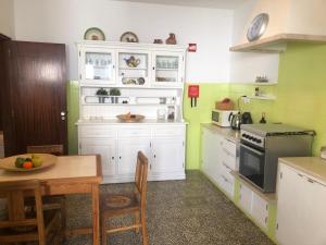 a kitchen with white cabinets and a table and a stove at Casa da Bisa in Sagres