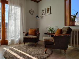 a living room with two chairs and a table at Palmehüüsle in Herten
