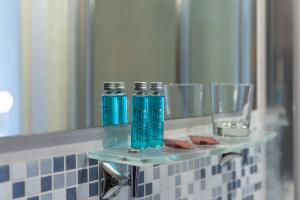 a bathroom mirror with two blue bottles on a shelf at Caelum Hyblae in Ragusa +21 photos
