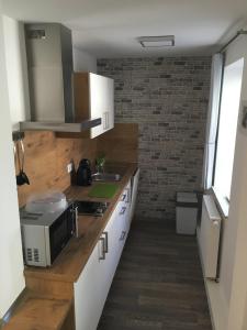 a kitchen with white cabinets and a microwave at Apartment 04 in Igersheim