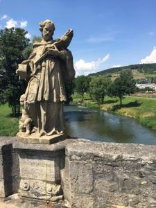 a statue of a man standing next to a river at Apartment 04 in Igersheim