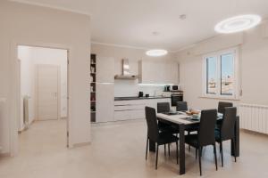 a kitchen and dining room with a table and chairs at JOY Appartamenti in Castiglione del Lago