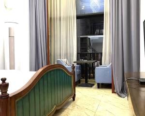 a bedroom with a bed and a table and chairs at April Fair Duplex Apartment Guagnzhou South Railway Station Min Jie Branch in Guangzhou