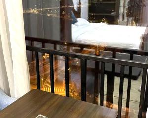 a bed sitting on a balcony with a table at April Fair Duplex Apartment Guagnzhou South Railway Station Min Jie Branch in Guangzhou