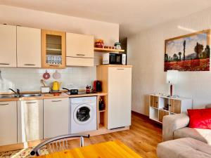 a kitchen with a washing machine in a room at Strategico per escursioni - Balcone con Vista in Gallio
