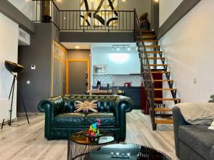 a living room with a leather couch and a staircase at Paradise Vista in Poblado de Sancti Petri +29 photos