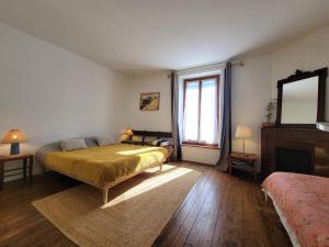 Un dormitorio con una cama y un espejo y una ventana. en La Bycoque, maison 2 chambres au calme, en Thomery